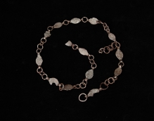 Żelazny pas łańcuchowy z Wąwelnicy (pow. policki), złożony z 13 blaszanych ogniw o migdałowatym kształcie, połączonych pierścieniami, 103,4 cm, starszy okres przedrzymski (IV–III w. p.n.e.), fot. G. Solecki/A. Piętak